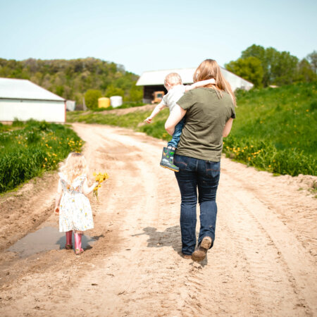 business owner of Midst of Motherhood and dairy farm family walking on path